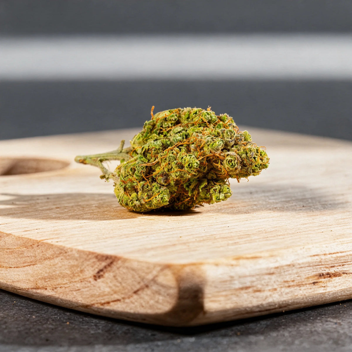 Super Lemon Haze CBD Blüten Nahaufnahme auf hellem Birkenholzbrett im Tageslicht
