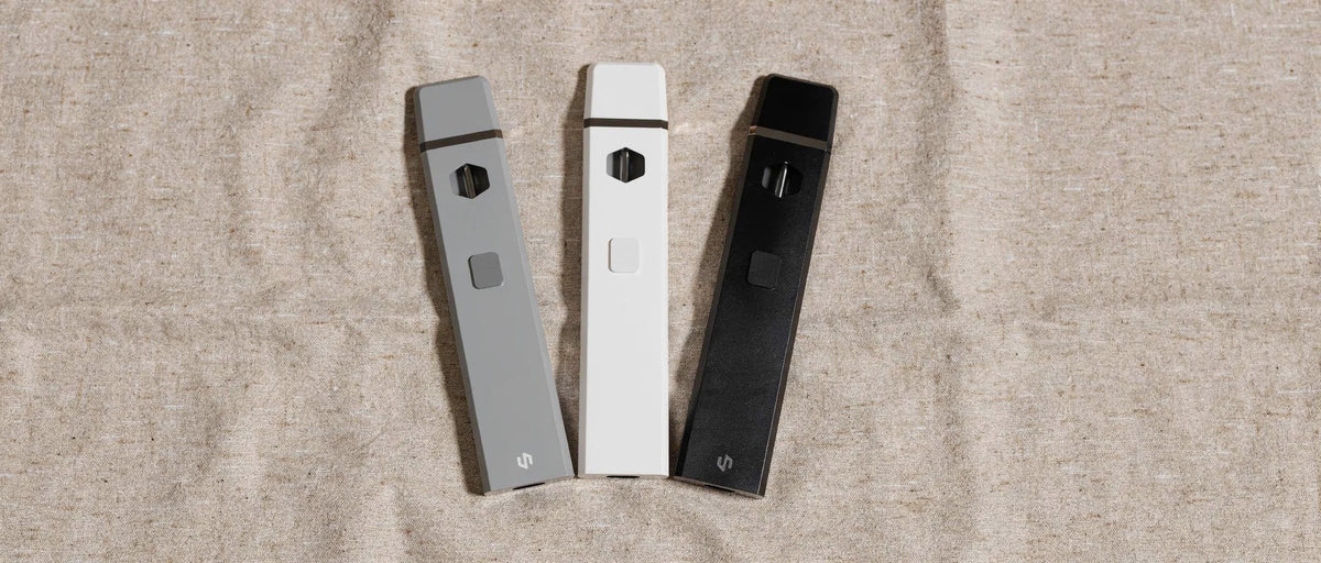 Drei CBD Vapes in Grau, Weiß und Schwarz auf Leinen, CBD Vape Erfahrungen